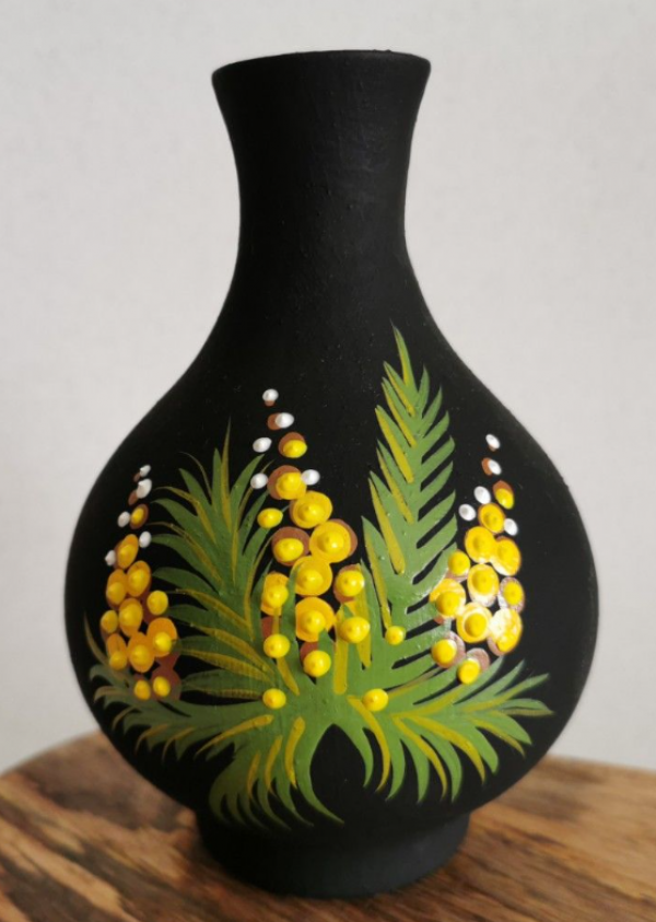 Vas bunga keramik berwarna gelap dengan motif floral